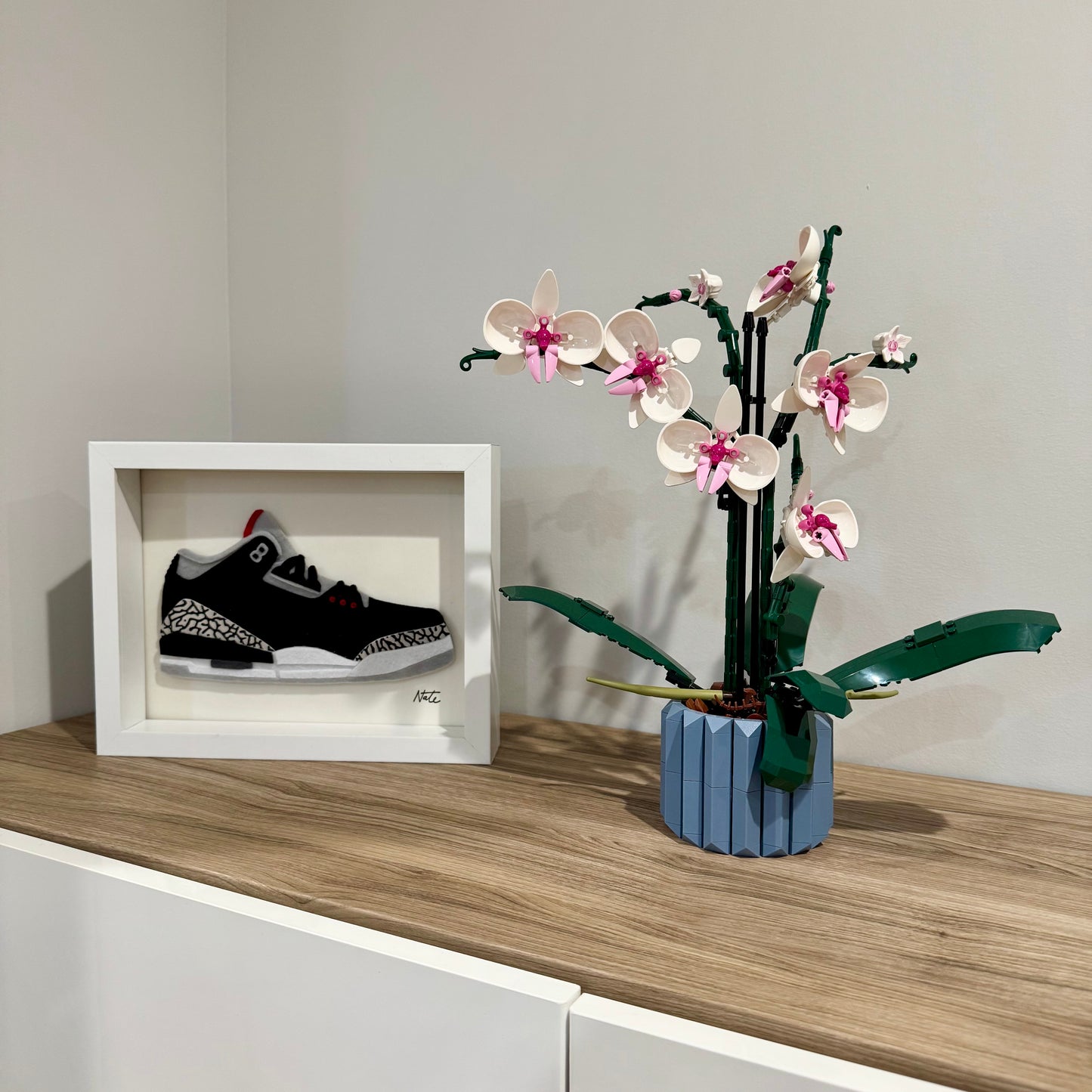 Handmade felt sneaker art with black elephant print accents, framed