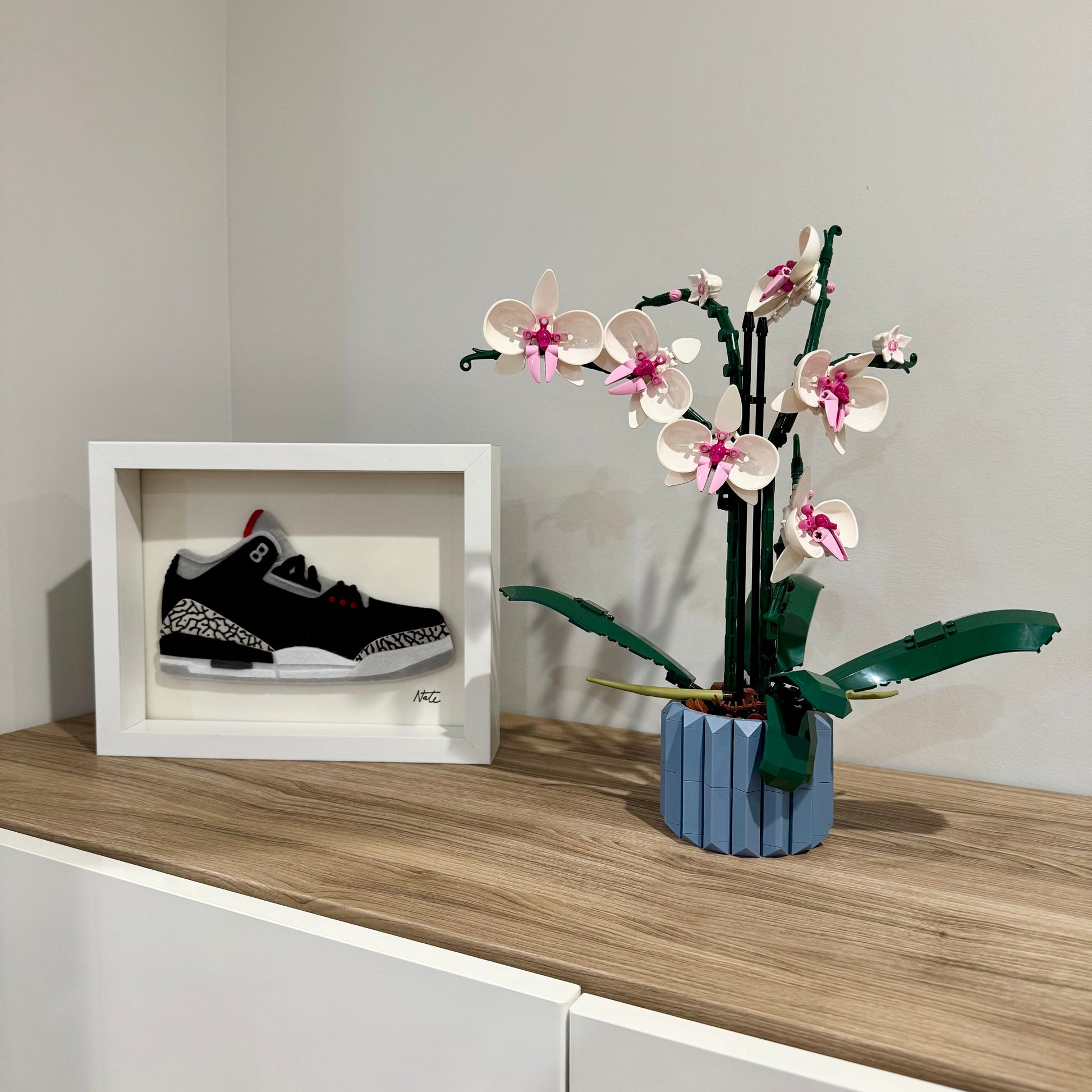Handmade felt sneaker art with black elephant print accents, framed