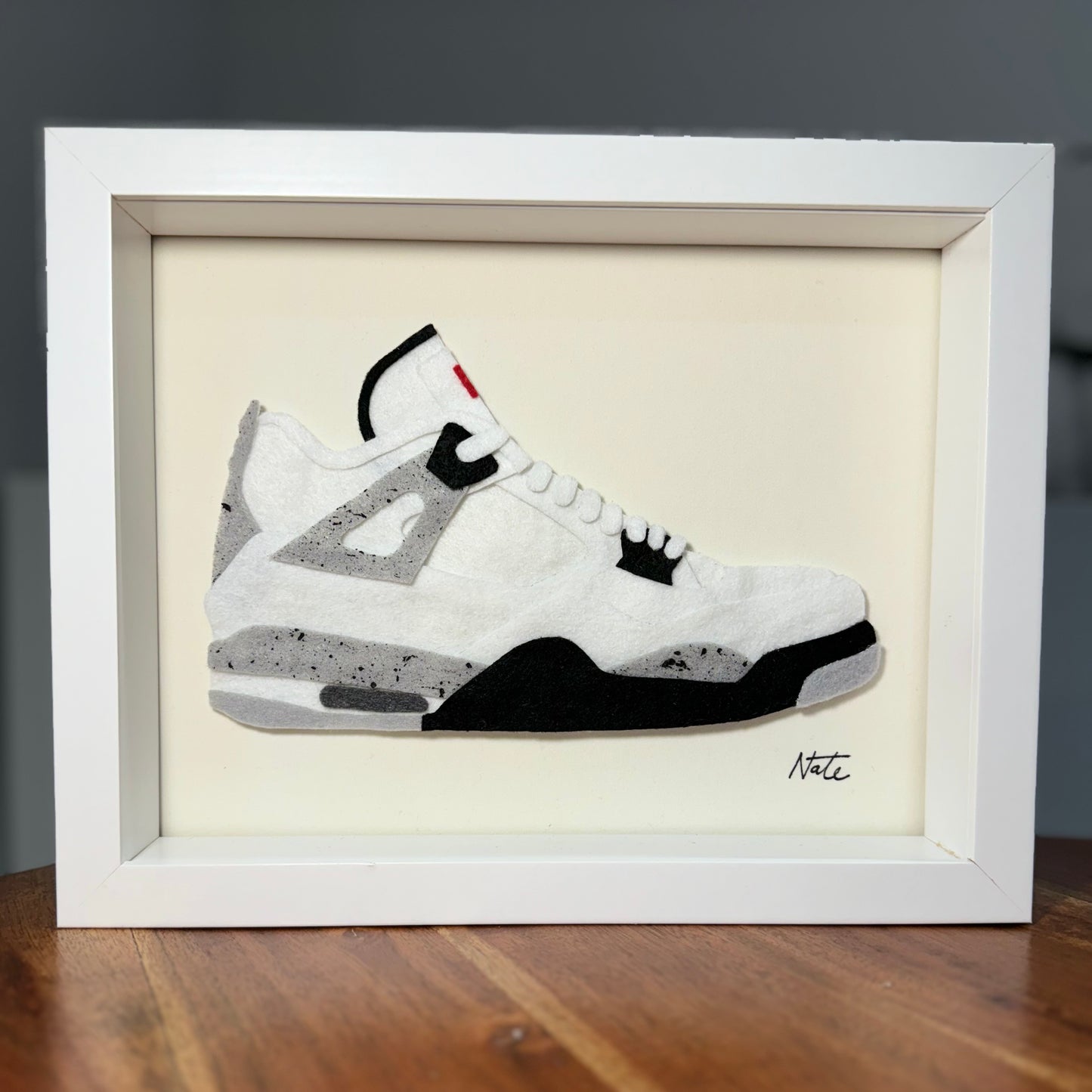 Handmade felt sneaker art in black and white mid-top colorway, framed