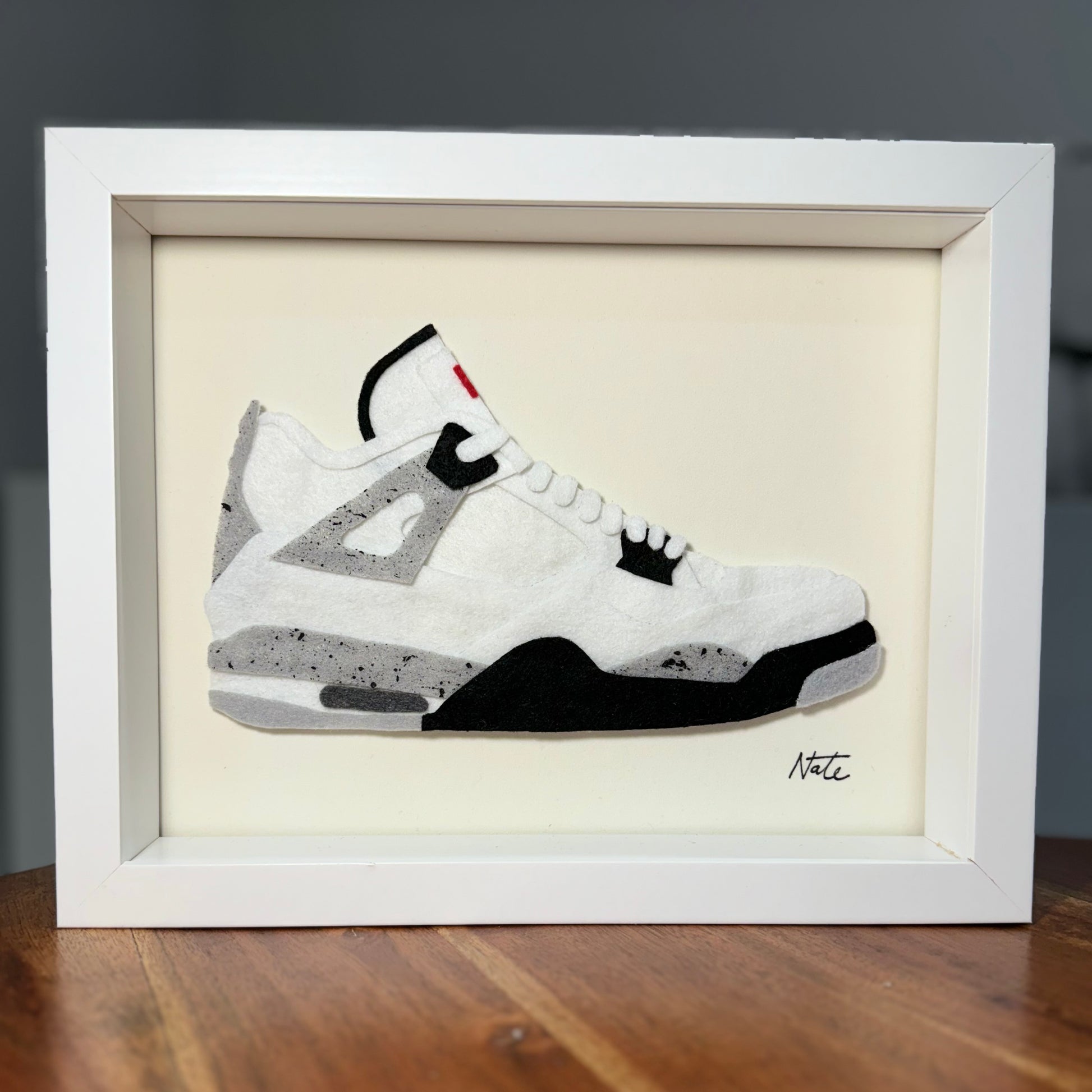 Handmade felt sneaker art in black and white mid-top colorway, framed