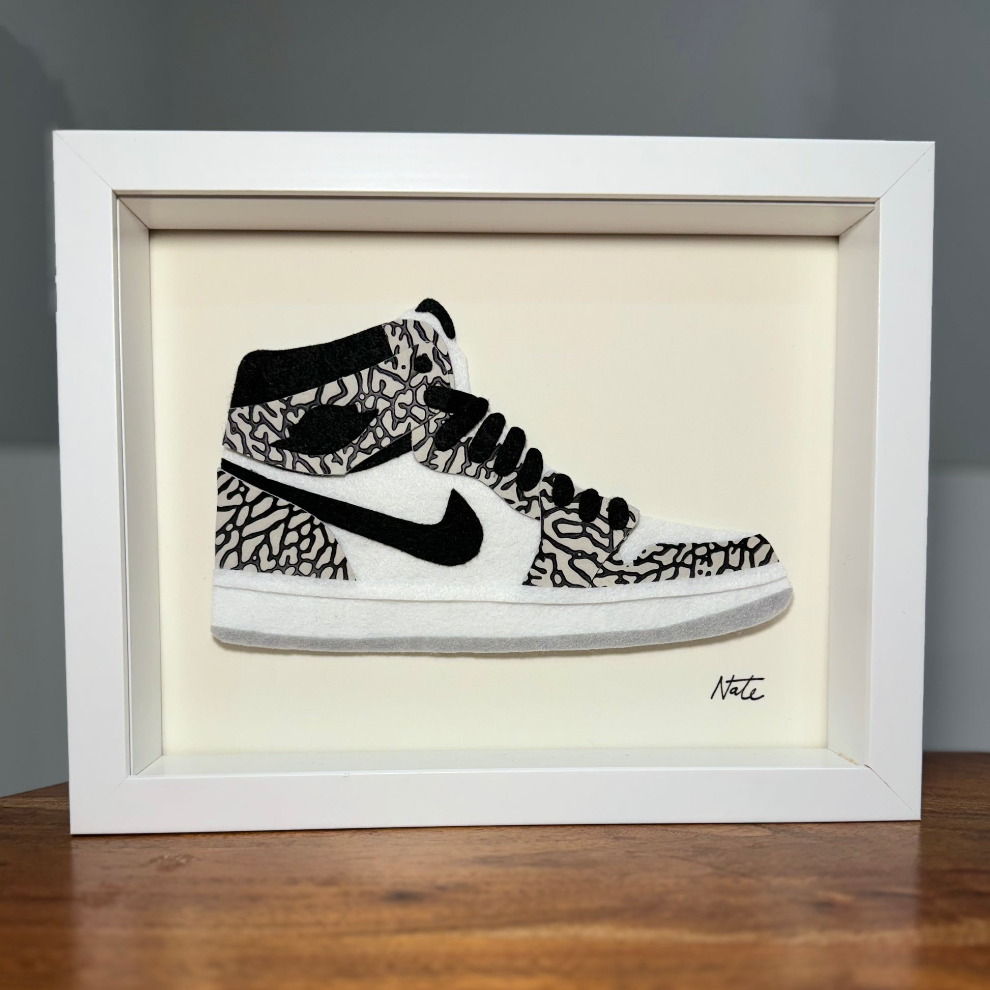 Handmade felt sneaker art with elephant print accents, framed