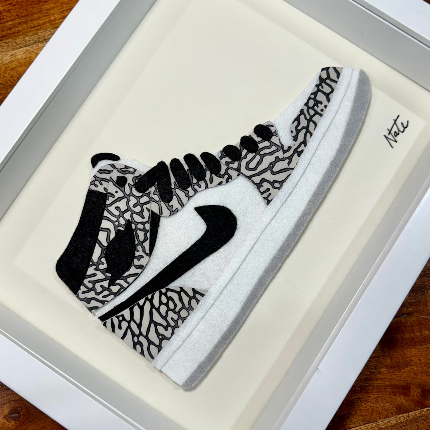 Handmade felt sneaker art with elephant print accents, framed
