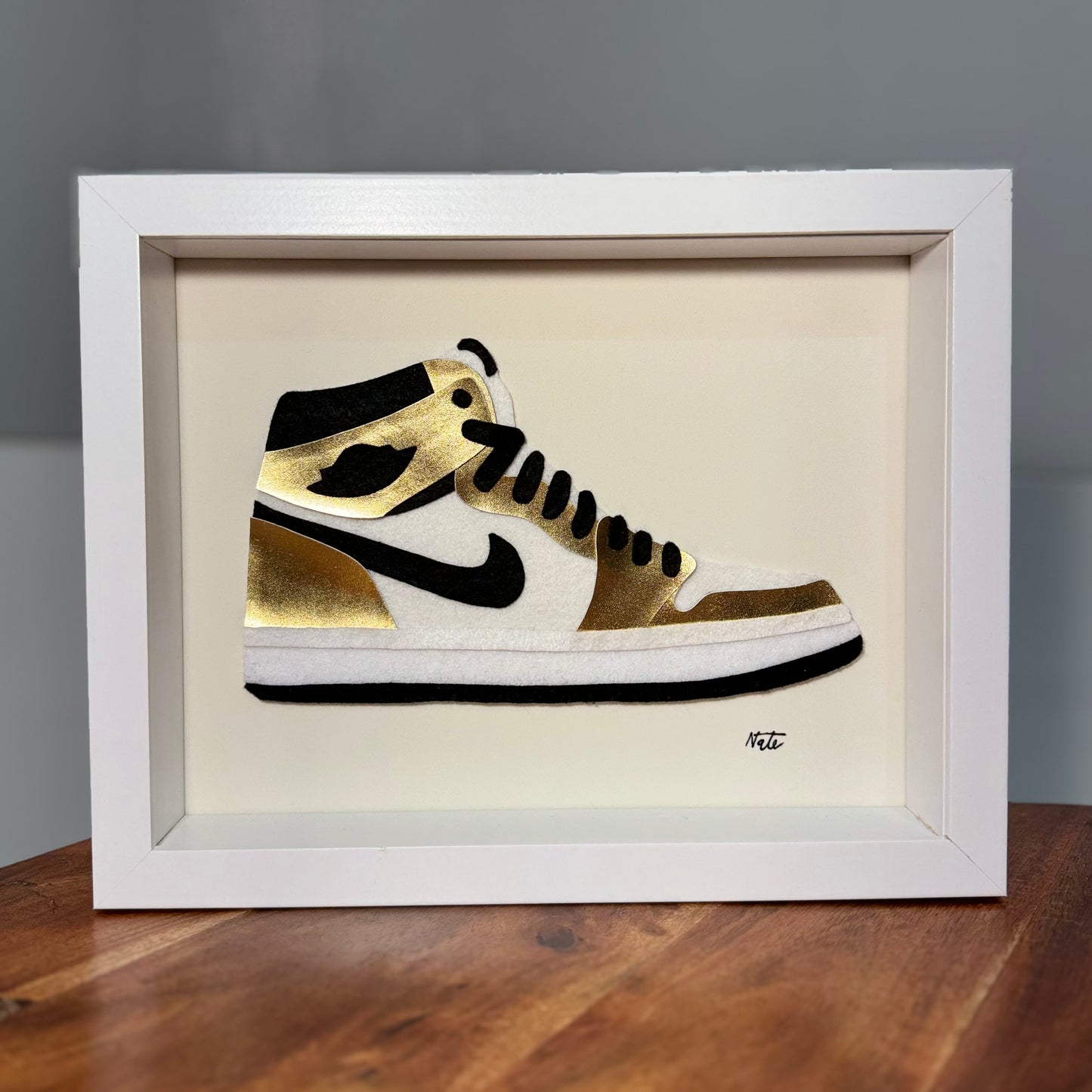 Handmade felt sneaker art in gold high-top colorway with black and white accents, framed