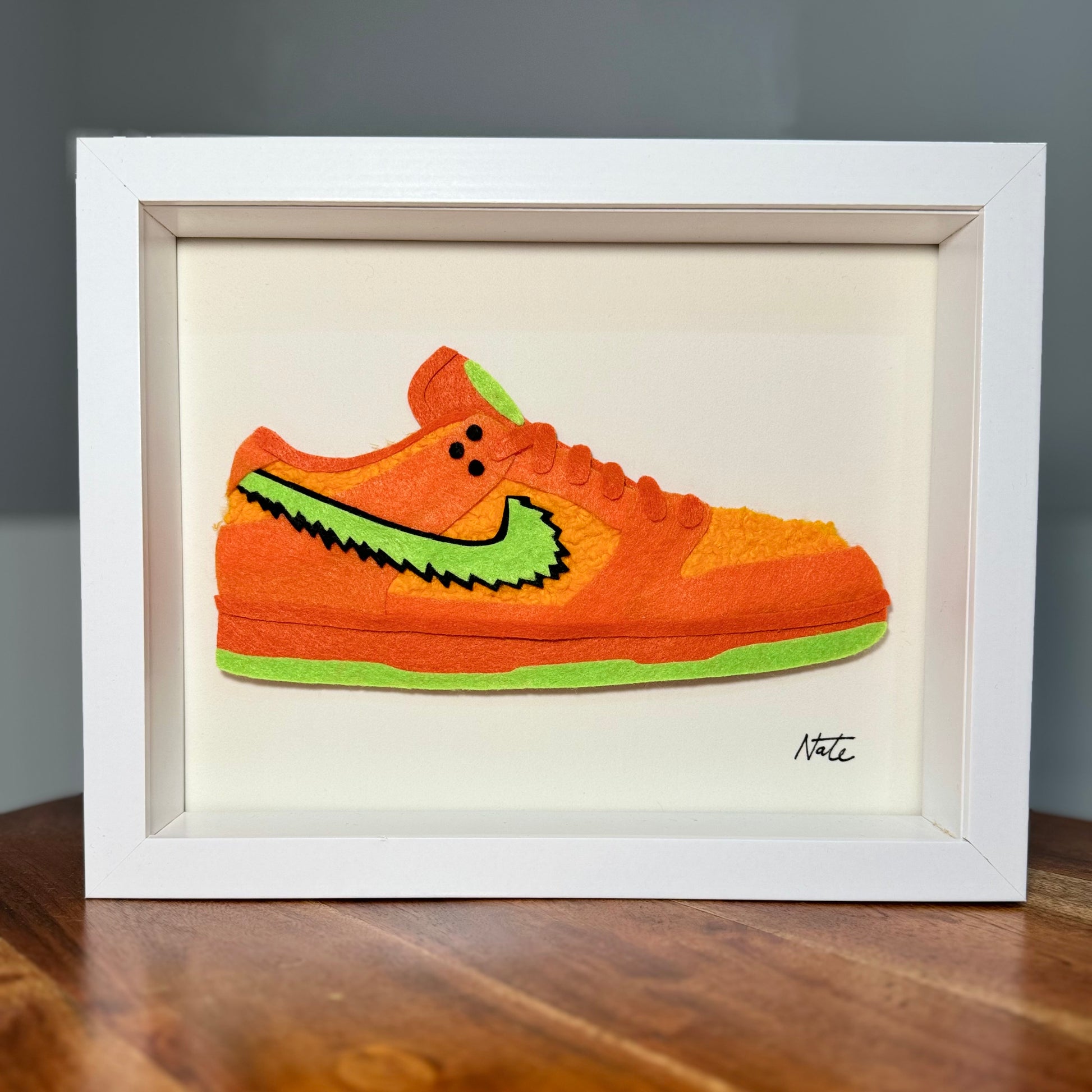 Handmade felt sneaker art with orange bear faux fur accents, framed