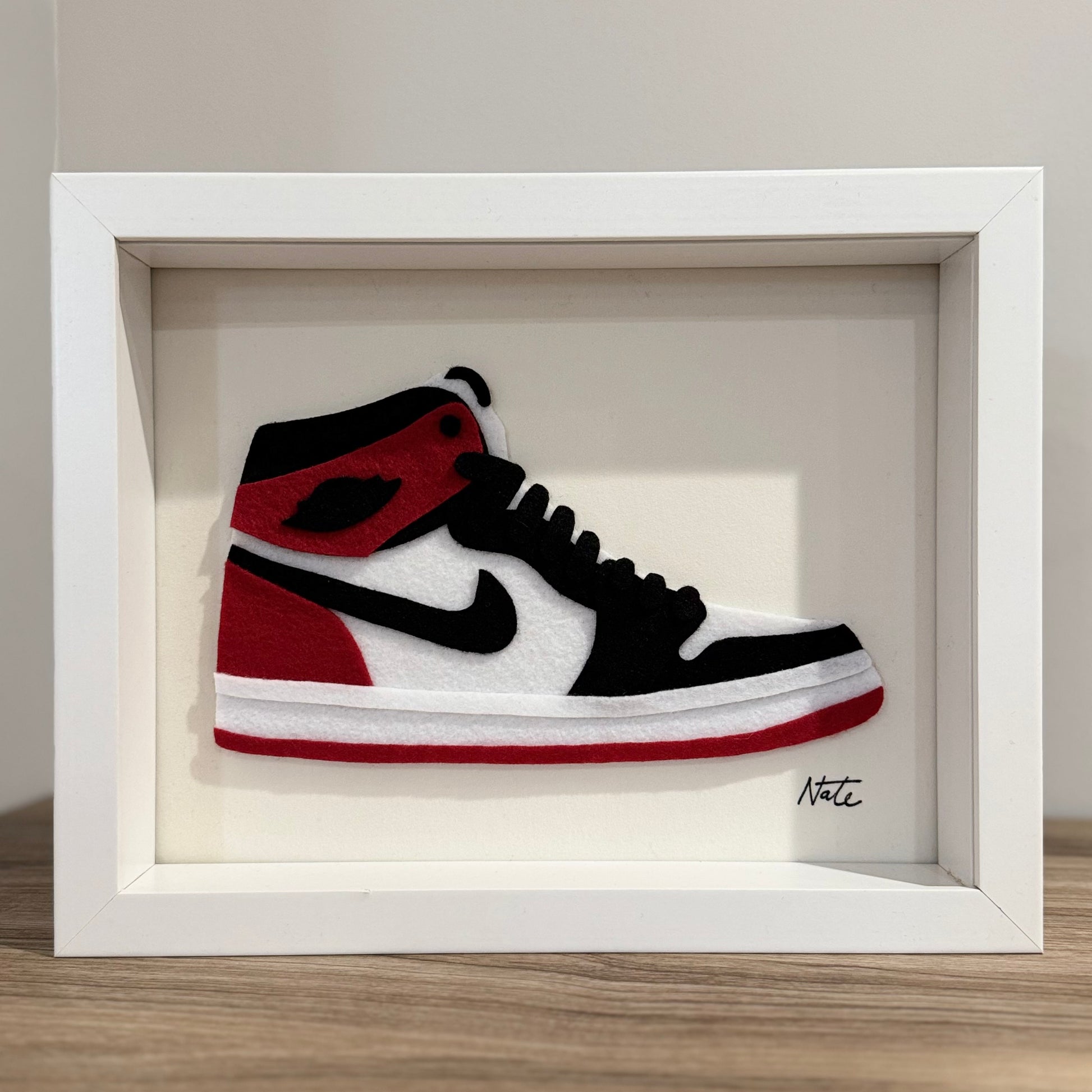 Handmade felt sneaker art in red and black high-top colorway, framed