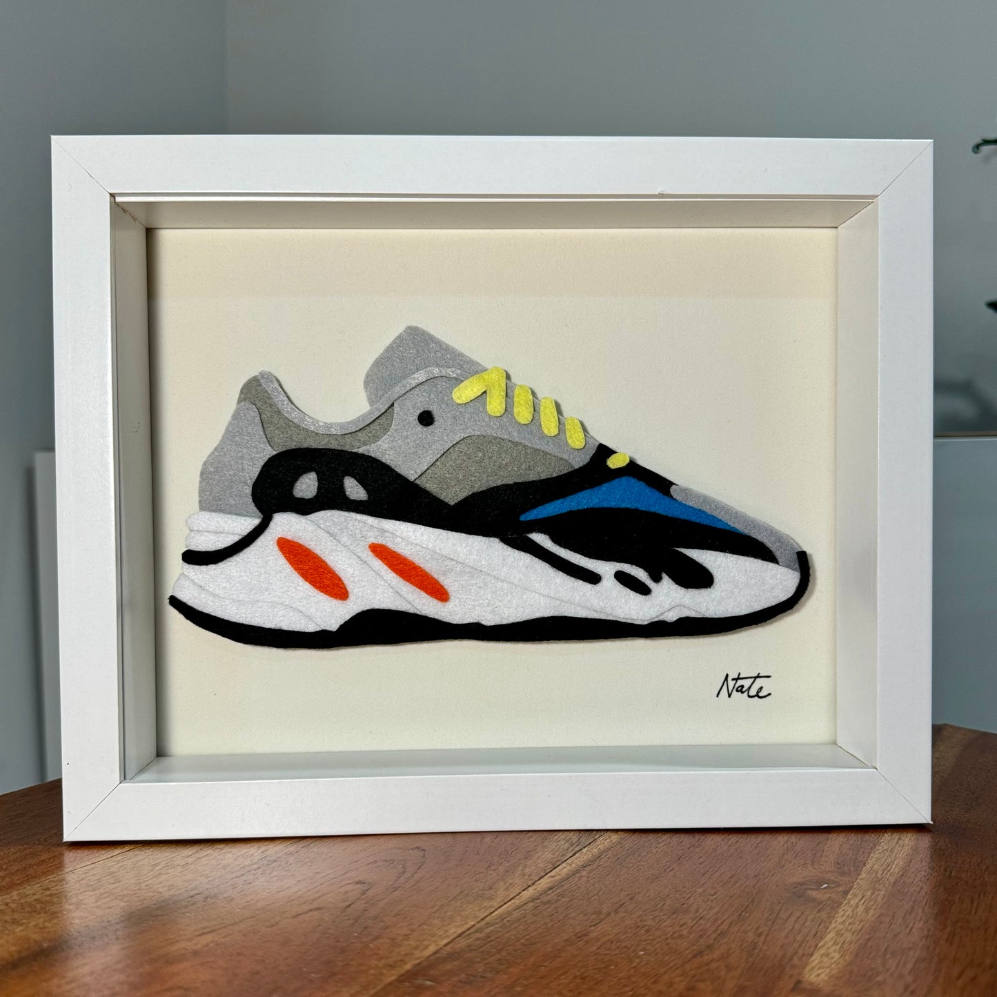 Handmade felt sneaker art with wavy multicolor design, framed