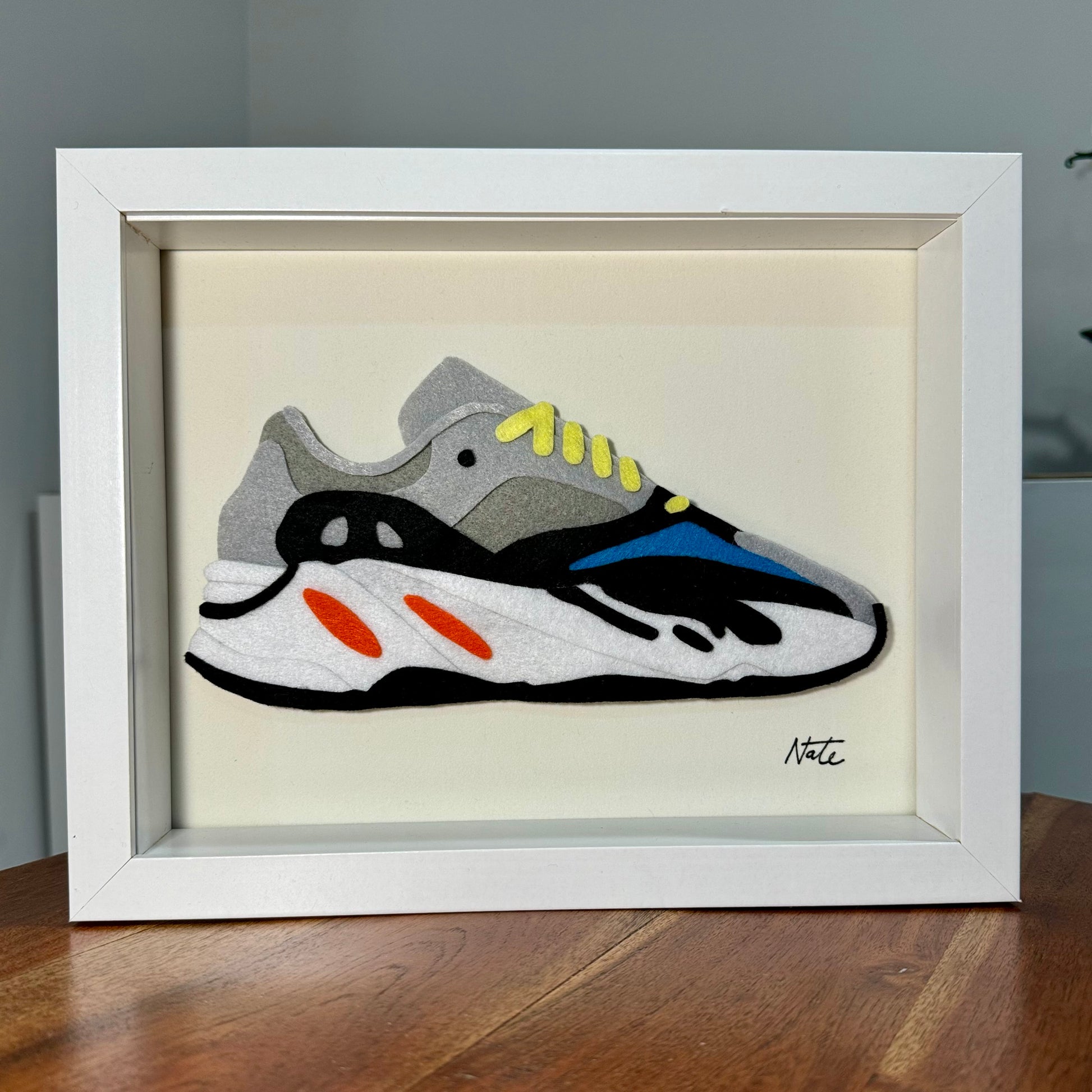 Handmade felt sneaker art with wavy multicolor design, framed