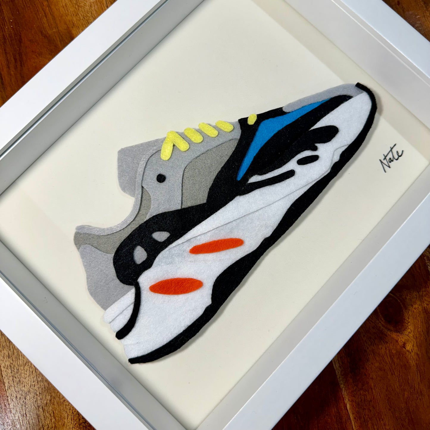 Handmade felt sneaker art with wavy multicolor design, framed